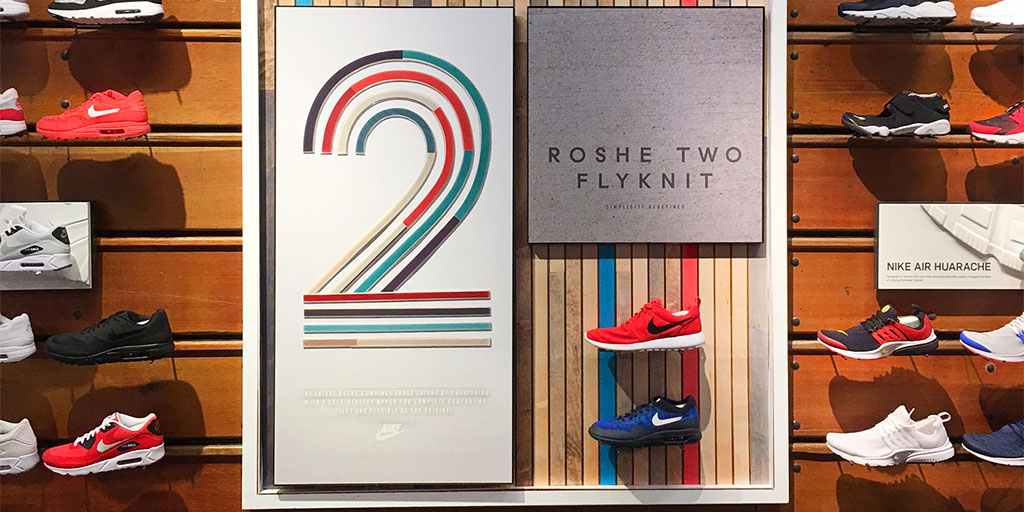 Image of a footwear wall display with custom routed wood 2 standing out from graphic