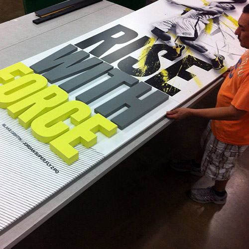 Image of a man preparing a graphic with 3D letters for shipping