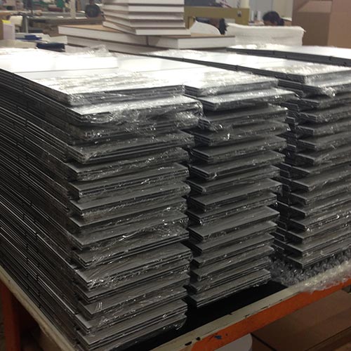 Image of a stack of plex signs waiting to be packed for shipping