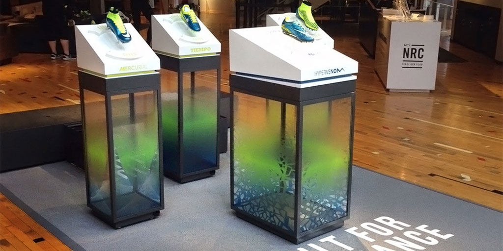 Image of three pedestals with clear acrylic sides printed with a colorful graphic