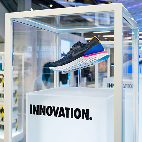 Image of a shoe displayed in a custom pedestal as part of a graphic roll out